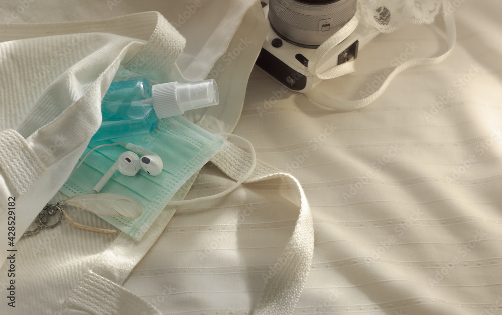 medical surgical mask and alcohol spray with white cotton bag.