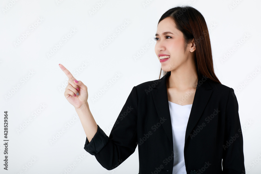 Portrait of an asian beautiful business woman with long hair wearing formal black suit, smiling, pointing and presenting copy space with isolated white background. Portrait of an asian beautiful business woman with long hair wearing formal black suit, smiling, pointing and presenting copy space with isolated white background.