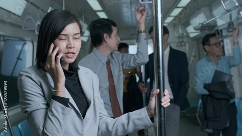 Young businesswoman happily chatting on the phone on a late night train while returning home after work.