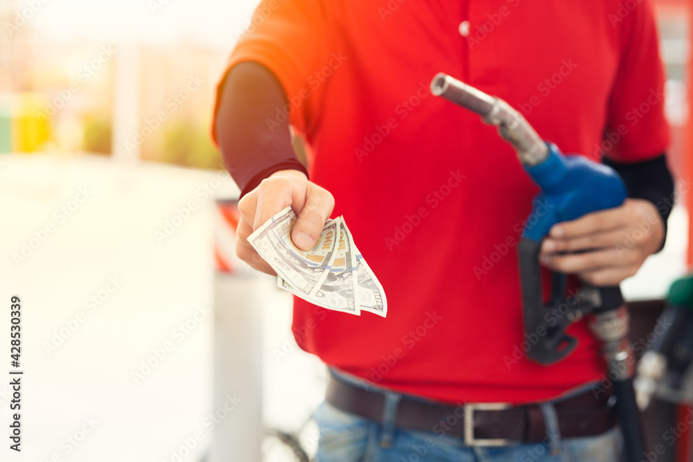 Gas station staff worker return the money back for lower fuel price, gas costs reduction, cut saving gasoline drop price and pay cash back concept