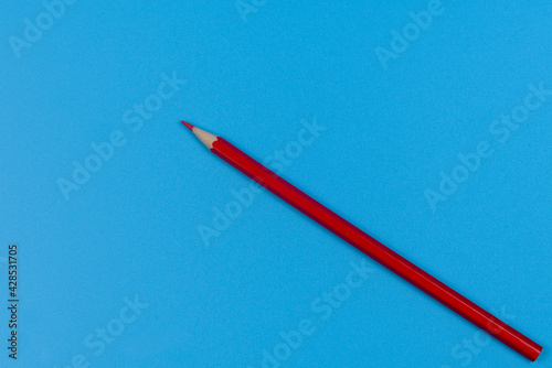One red pencil on a blue background