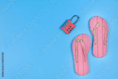 Slippers and combination lock on a blue background.