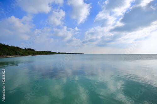 青空が写りこんだエメラルドグリーンの海