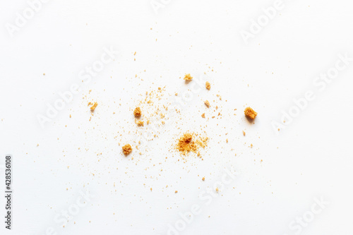 scattered crumbs of white bread rusks on a light background photo