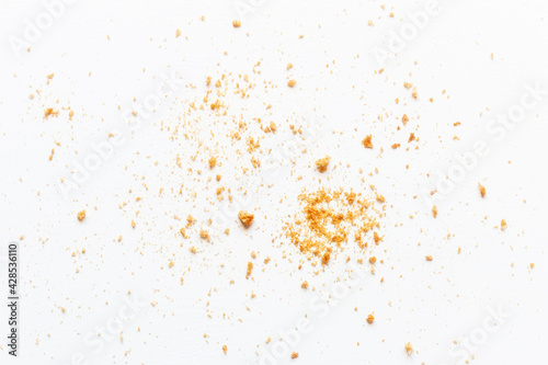 scattered crumbs of roasted white bread on a white background closeup photo