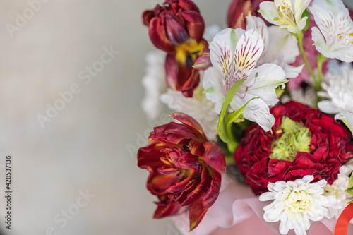 A bouquet of lush red white flowers of different sizes with green stems. Close-up. Place for text