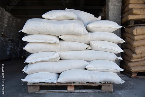 Large bags of flour are stacked on a pallet.