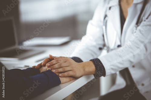 Unknown woman-doctor is reassuring her female patient  close-up. Physician is consulting and giving some advices to a woman. Concepts of medical ethics and trust. Empathy in medicine