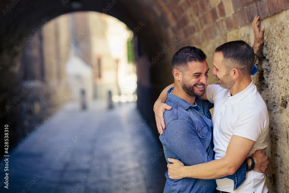 Gay couple laughing together in a romantic moment.