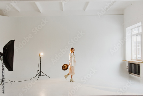 Beautiful young pregnant woman in dress and hat in the studio.