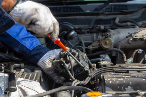 Check engine ignition system and change ignition coil. Car care service..Replacing ignition coil and spark plugs..Car mechanic fixing ignition coil on gasoline, cylinder combustion engine.