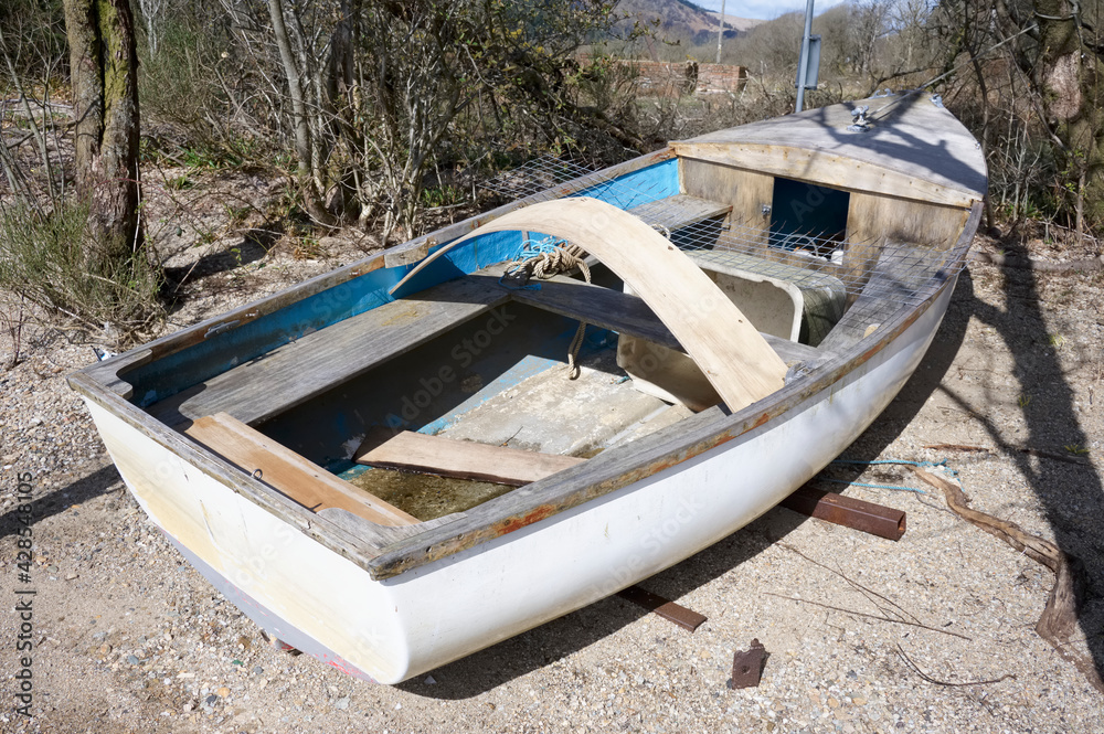 Single white boat moored alone on land during summer