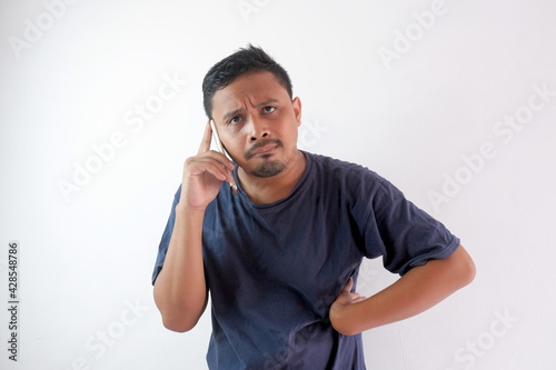 impatient man talking on phone with hand on the waist