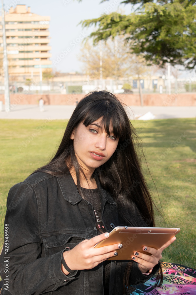 Fototapeta premium green eyed latina teen girl playing with the table in the park