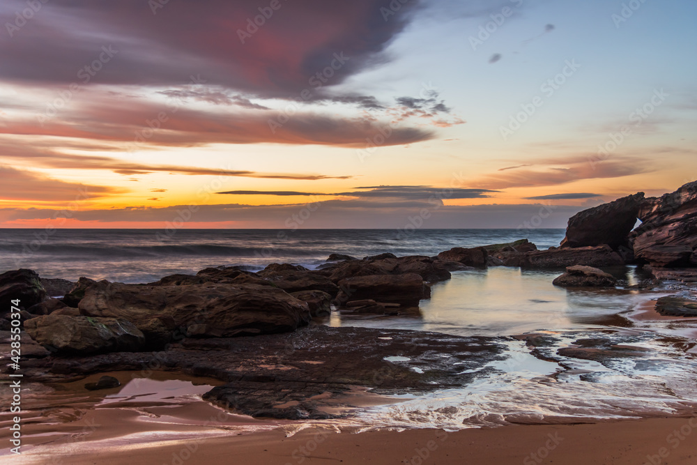 Obraz premium Sunrise at the seaside with pastel coloured clouds
