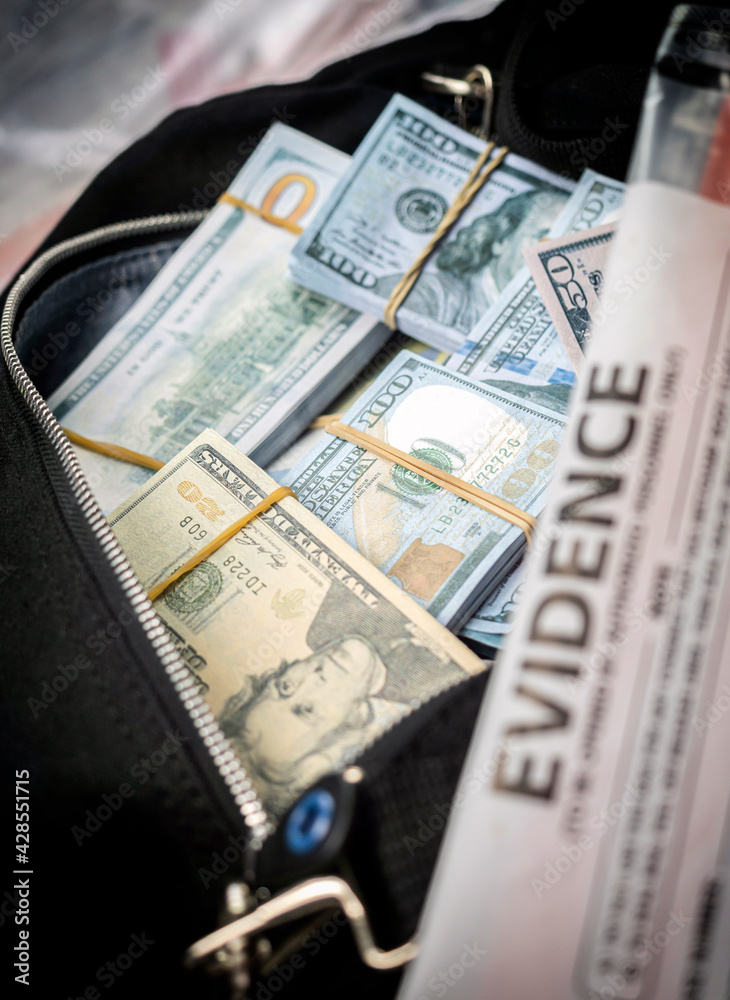 Black duffel bag full of dollar notes in criminal investigation unit, conceptual image Black duffel bag full of dollar notes in criminal investigation unit, conceptual image