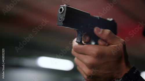 Policeman hands aiming gun. Male cop holding finger on trigger of pistol