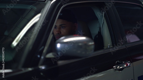 Police man sitting in patrol car. Serious cop getting out of patrol suv