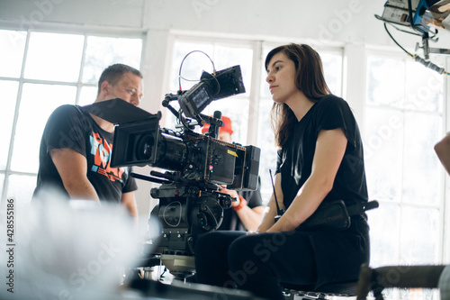 Female director of photography with a camera on a movie set. Professional videographer on the set of a movie photo