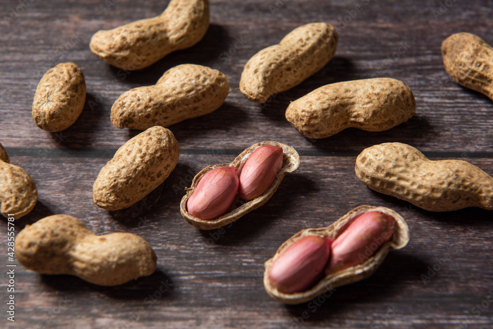 Obraz premium Raw fresh peanuts on wood background