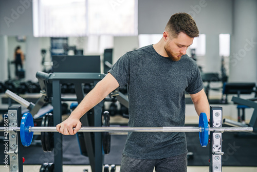 Fitness attractive man training in the gym. Healthy handsome young trainer working in the gym.