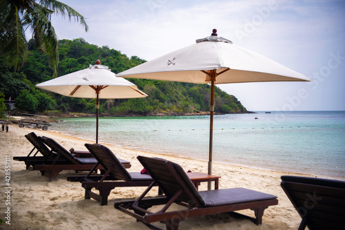 Beach chair under coconut tree looking away to sea view. Praw Bay, Samed,Thailand.