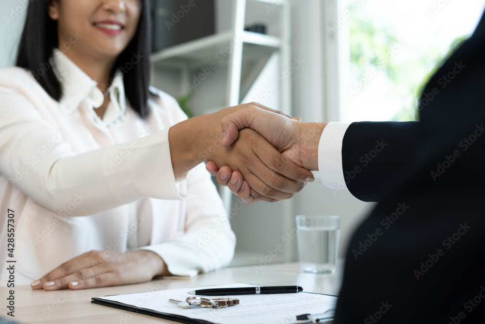 The real estate agent shakes hands with the client after agreeing to a contract for the sale of the home or insurance with legal effect. Success in house trading negotiations. Home or land mortgage The real estate agent shakes hands with the client after agreeing to a contract for the sale of the home or insurance with legal effect. Success in house trading negotiations. Home or land mortgage