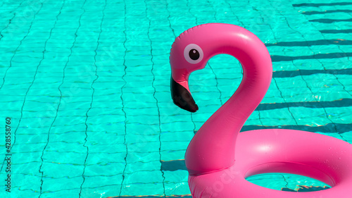 Summer holiday poster. Pink inflatable flamingo in pool water for summer beach background. Funny bird toy for kids. © Maksym
