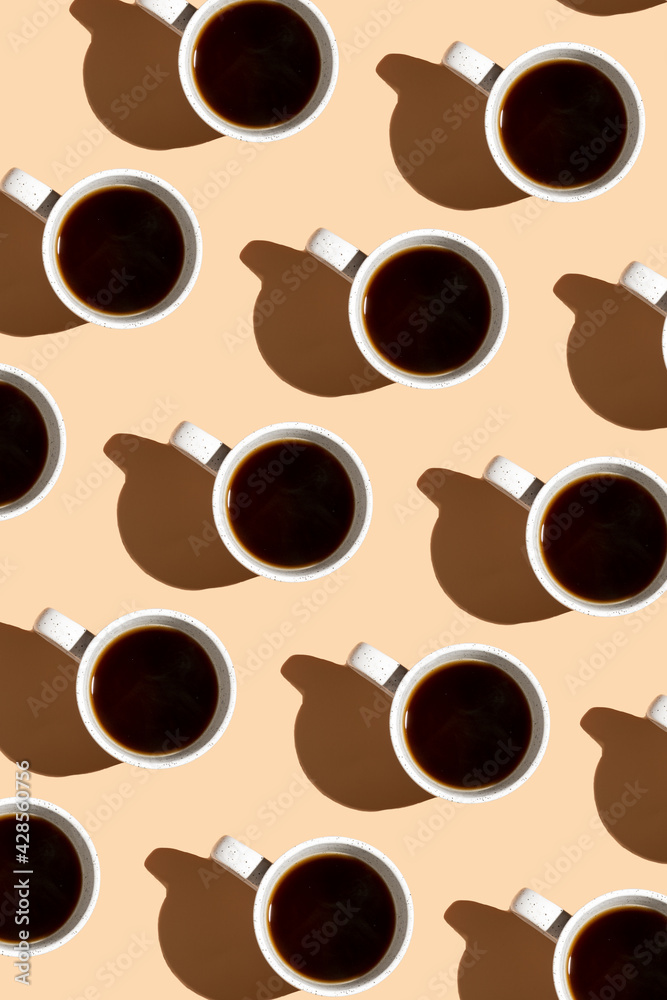 Obraz premium A top view on a coffee cup on beige surface, a hard light pattern