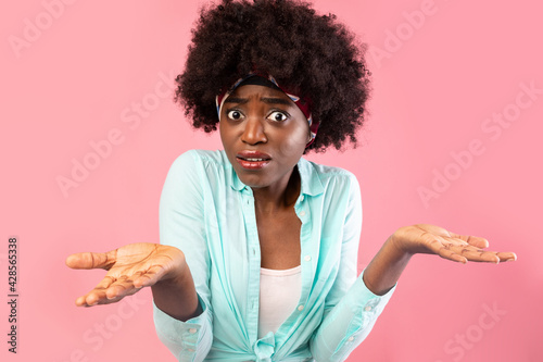 Puzzled African Lady Shrugging Shoulders Standing Over Pink Background
