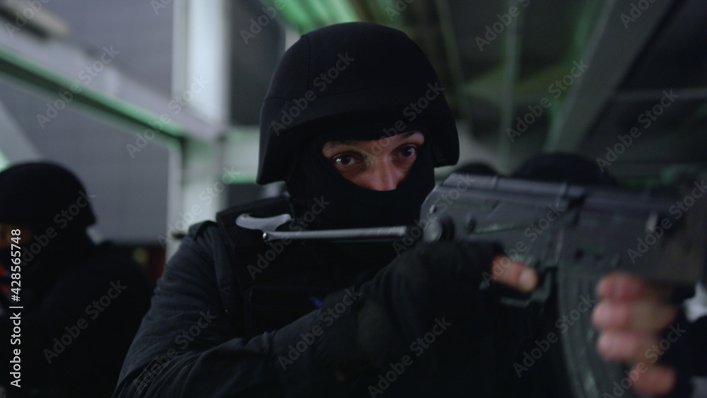 Masked military soldiers targeting scopes on rifles. SWAT team exploring bridge Masked military soldiers targeting scopes on rifles. SWAT team exploring bridge