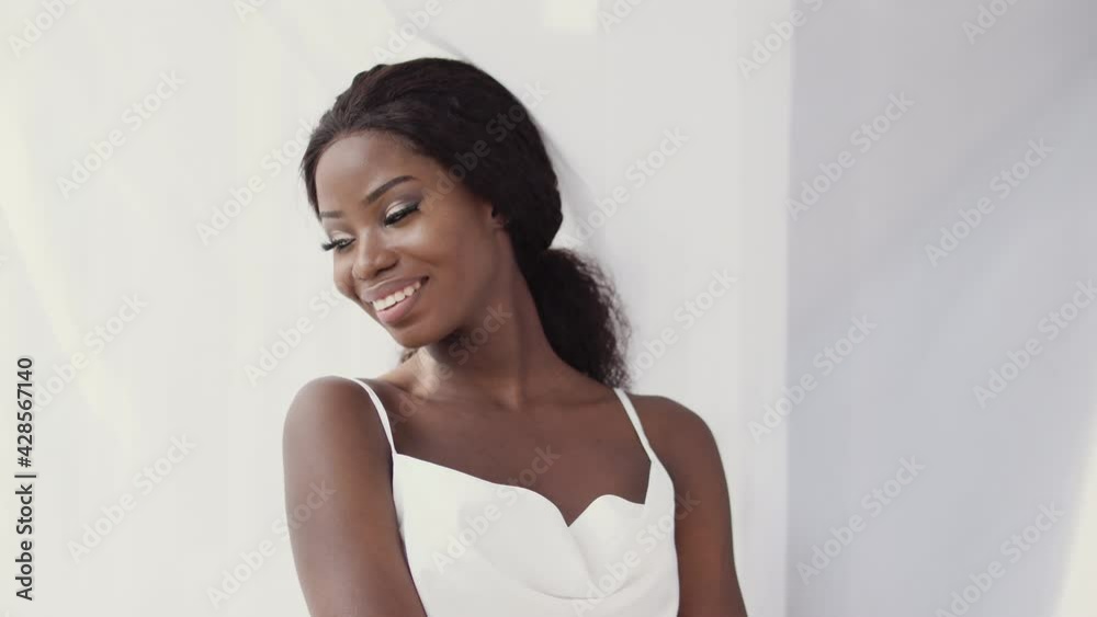 Attractive black woman in white top smiling at camera, beauty of diversity Attractive black woman in white top smiling at camera, beauty of diversity