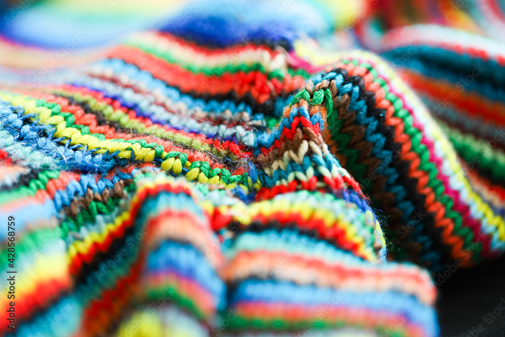 Colorful rainbow striped wool textile close up with folds