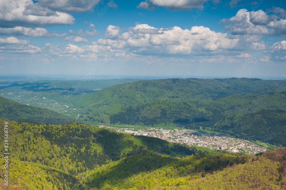 panorama of mountainous terrain with a small town in the river valley