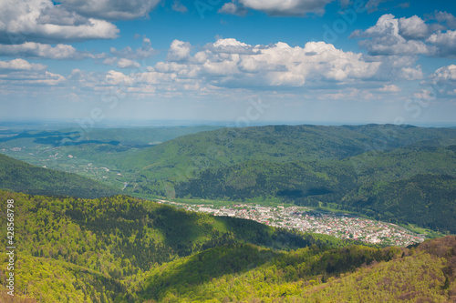 panorama of mountainous terrain with a small town in the river valley © Yurii Klymko