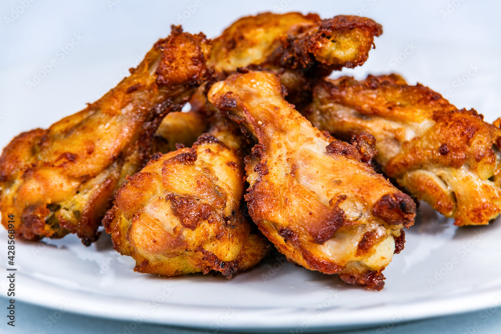 Fried chicken thighs on a white plate. The food in the restaurant. Food styling and restaurant meal serving. Fried chicken thighs on a white plate. The food in the restaurant. Food styling and restaurant meal serving.