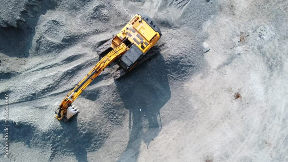 Aerial view of an earth excavator machine in an open field at Pune India.