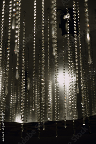 Close-up of a decorative element of the interior: crystals in the form of rain. Suspended from the ceiling. In black and white