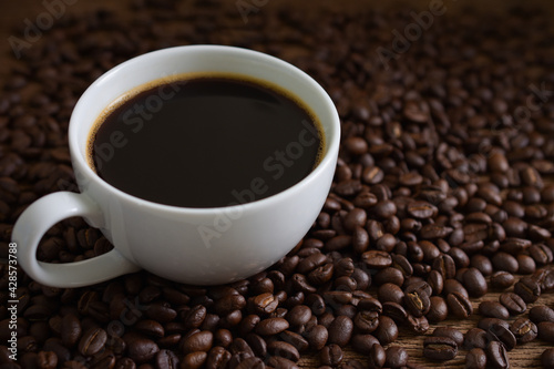  Coffee cup and coffee beans roasted on wooden background,copy space.