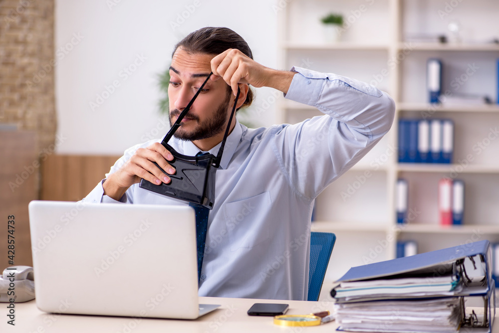 Young male employee wearing virtual glasses at workplace Young male employee wearing virtual glasses at workplace
