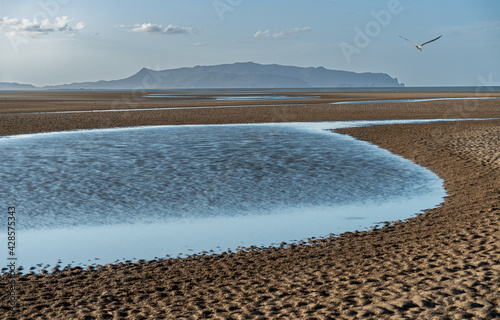 water ponds in the beach and the mountains in the background