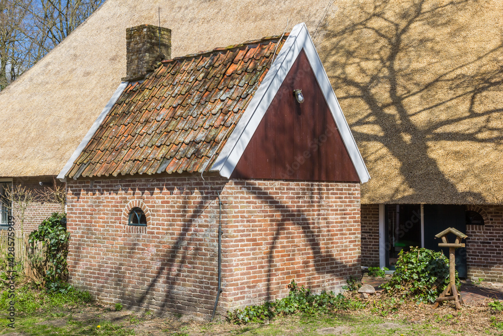 Little brick shed in front of a historic house in Orvelte, Netherlands