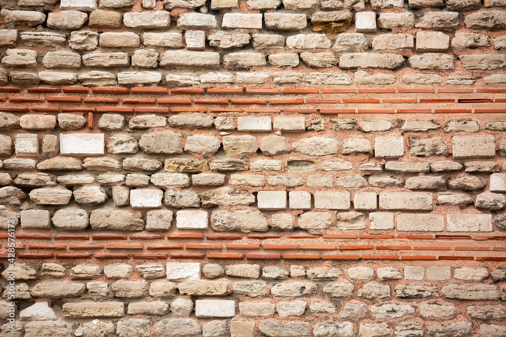 Old wall built of brick and stone, historic background