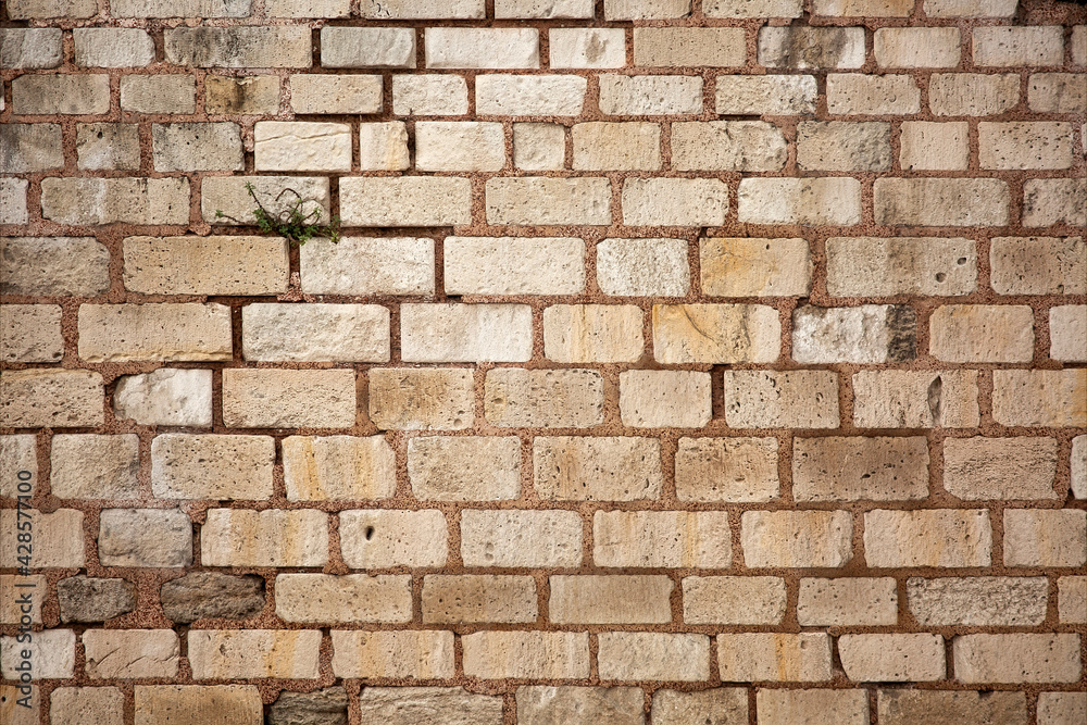 Old wall built of brick and stone, historic background Old wall built of brick and stone, historic background
