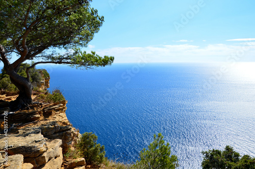 Stunning view from the cliff Cap Canaille near the town Cassis in South France towards mediterranean sea, reflections of sunlight on blue water surface