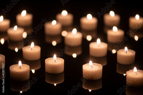 some tee candles on a black acrylic underground, background blurred