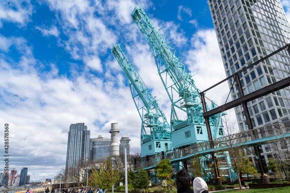 Brooklyn, NY - USA - April 17, 2021:The Gantry Cranes at the north end of Domino Park. A public park in the Williamsburg neighborhood of Brooklyn, the former site of the historic Domino Sugar Refinery