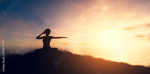 Woman in yoga pose, zen meditation at sunset.