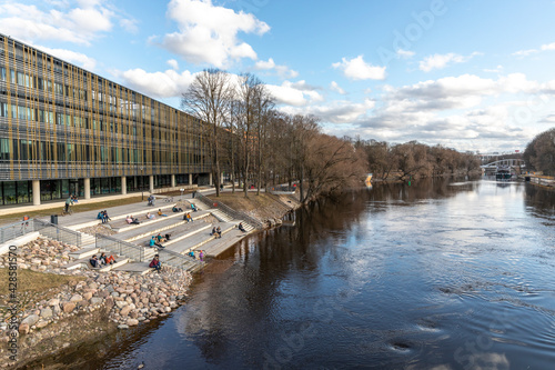 people resting at the riverbanks in Tartu photo