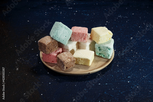 Marshmallow in a plate on a dark blue background